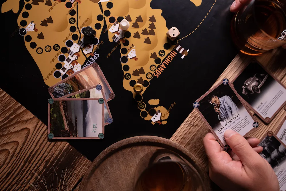 The Whisky Game in action – board with map of Scotland, character cards, and whisky glass
